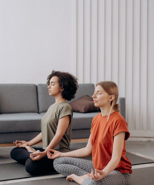 Person in a calm yoga pose in a minimalist dark room with azure light.